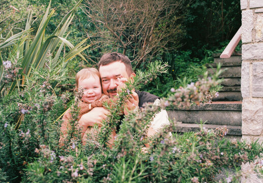 Dad and daughter behind the rosemary bush