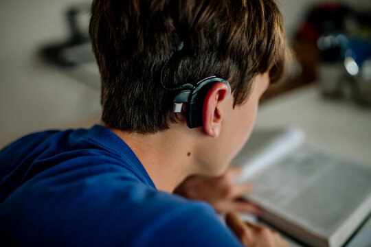 Teen Student with Cochlear Implant Doing Homework at Home