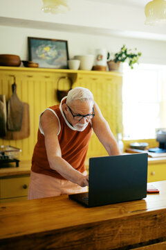 Portrait Of Lgbtq Man In Kitchen At Home using computer