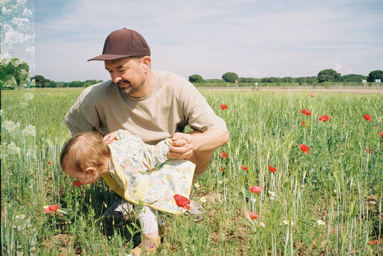Dad and daughter smelling flowers