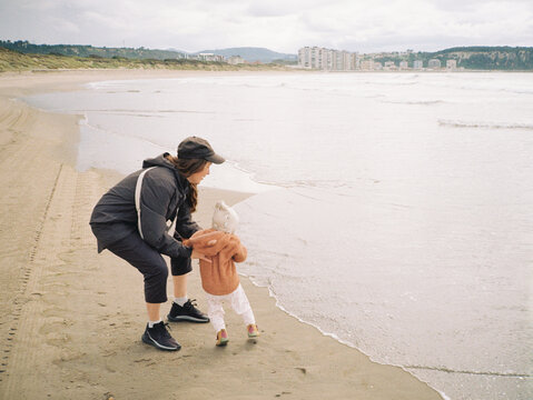 Anonymous woman and child near the ocean