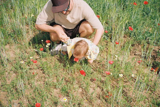 Anonymous dad and child smelling flowers