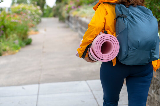 anonymous person walking on sidewalk with fitness gear backpack