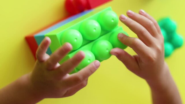 Join this little builder as they manipulate plastic blocks with focus and precision. This charming footage exemplifies the growth of fine motor skills and problem-solving abilities in young minds.