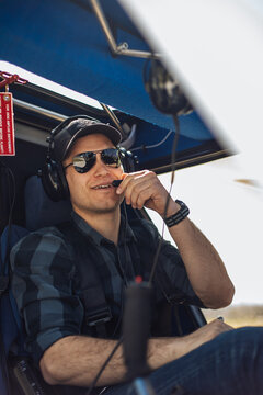 Smiling Helicopter Pilot Wearing Headset and Sunglasses