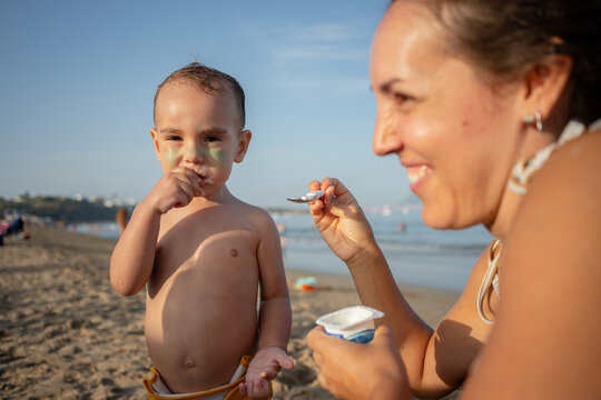 Mother feeding son yogurt