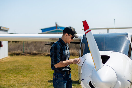 Pilot Performing Preflight Inspection On Small Plane