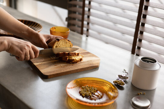 Slicing Fresh Artisanal Bread on a Modern Concrete Kitchen Counter
