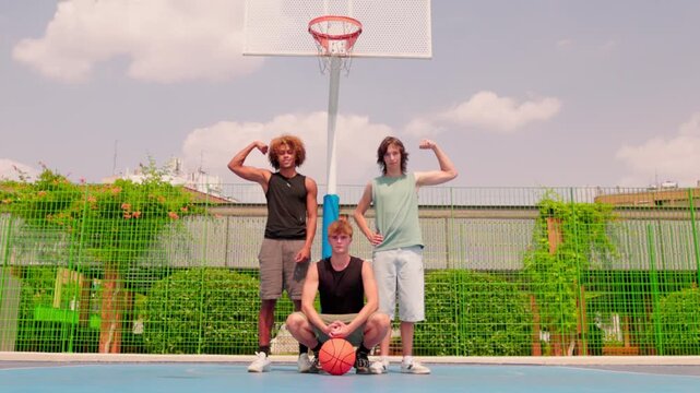 Multicultural male friends posing on an outdoor basketball court