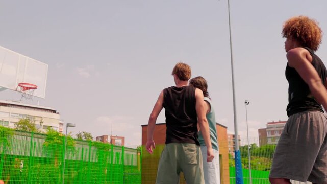 Multicultural friends shooting hoops on a sunny day