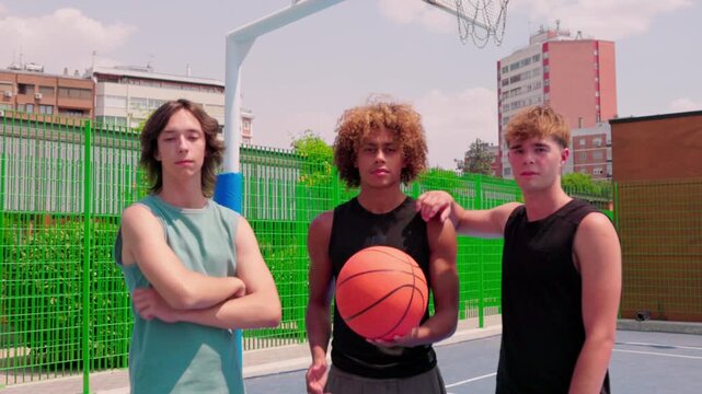 Multicultural male friends posing on a city basketball court