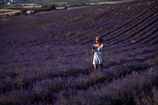 Woman lavender field standing in purple blossoms enjoying summer day
