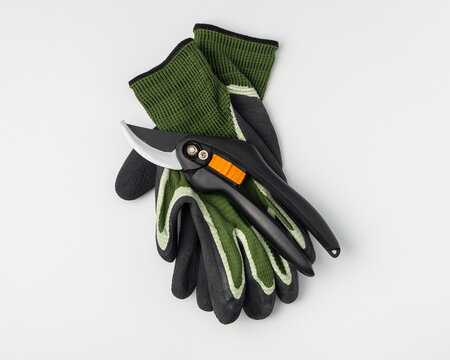 Garden secateurs and protective work gloves on grey background
