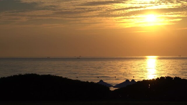 Stunning Sunset Over Tranquil Waters: A Scenic View of a Relaxing Evening by the Shore, Highlighting Nature's Beauty with the Sun Setting on the Horizon.