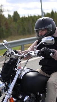 In this captivating shot, a motorcyclist embodies freedom as the headwinds create a perfect backdrop for their journey. The asphalt road beckons with promises of exploration and thrill.