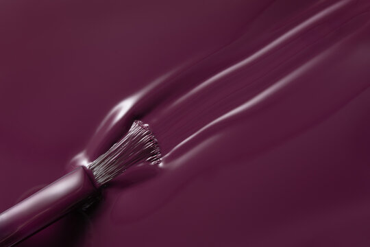 Burgundy nail polish stroke with brush close up