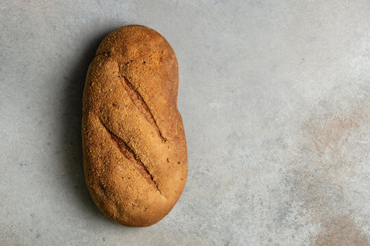 Artisanal rye bread loaf on rustic grey background