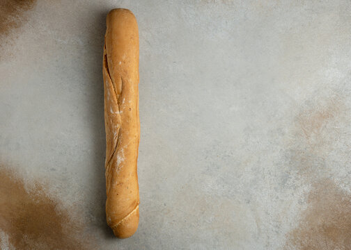 Artisanal French baguette bread on rustic grey background