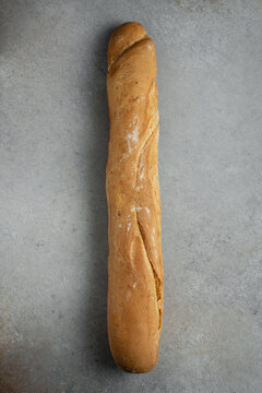 Artisanal French baguette bread on rustic grey background