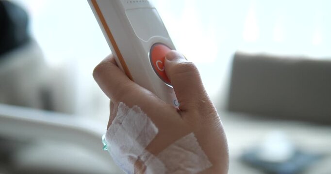 Close up of patient pressing nurse call button in hospital room