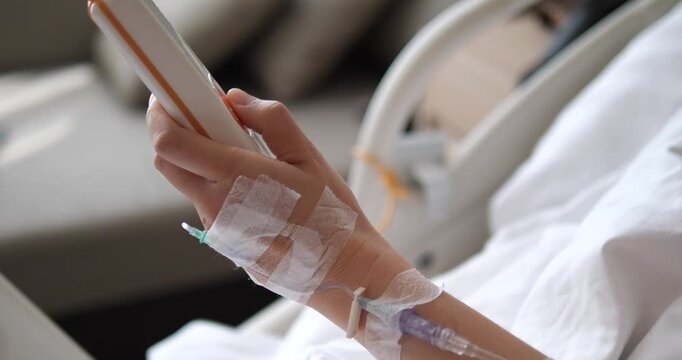 Side view of patient holding nurse call button on hospital bed