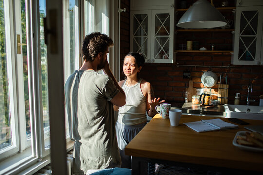 Couple arguing in a sunlit home kitchen