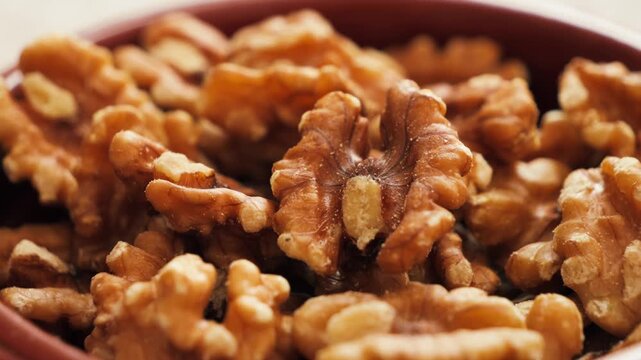 Close-up of walnut kernels in a bowl. Healthy organic nuts rich in protein and omega fatty acids for nutritious snacking and cooking.