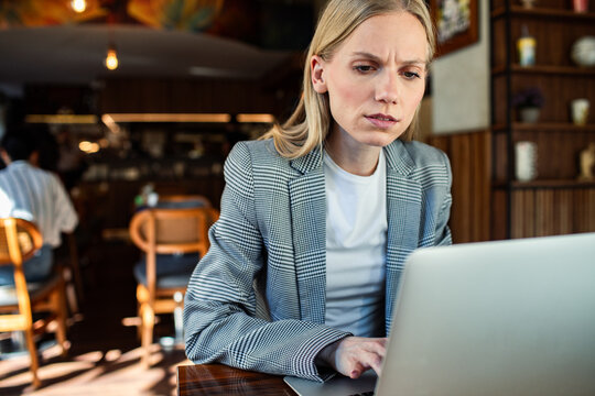 Concerned woman working on laptop in a cafe