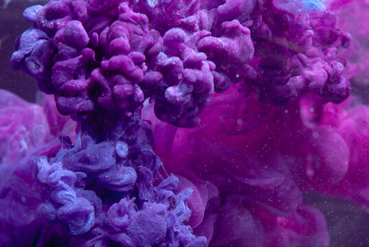 Colorful swirling patterns created by liquid mixing in a glass container