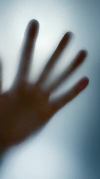 Hand Pressed Against Frosted Glass Seen from Behind Vertical