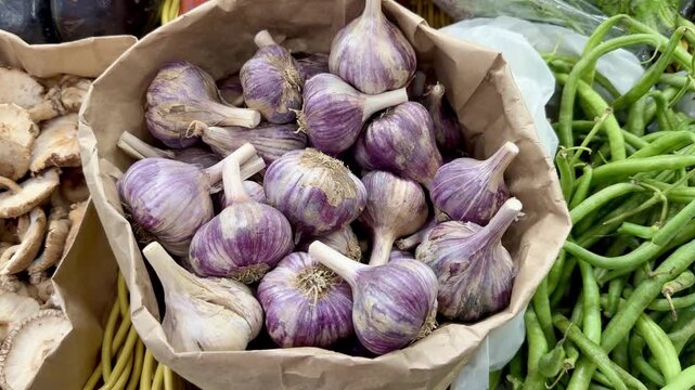 Purple Fresh Finnish Garlic Bulbs in a Paper Bag at a Market Stall