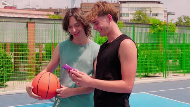 Young male friends using a smartphone on an outdoor basketball court