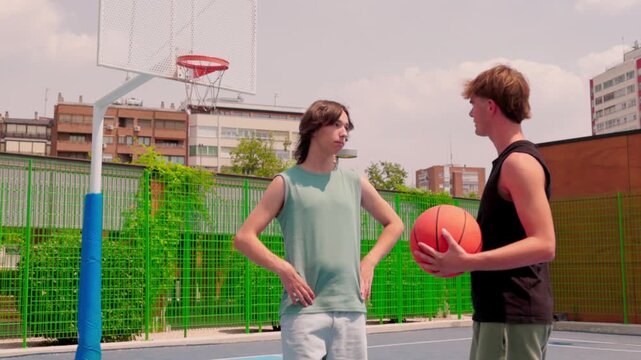 Young multicultural male friends talking on a basketball court