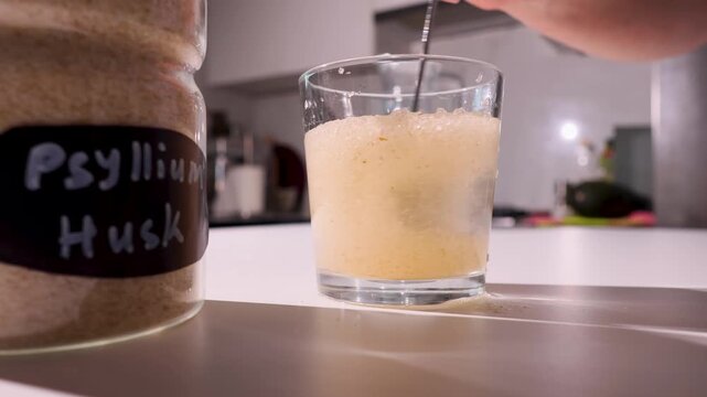 Textured psyllium husk in water forming a thickening gel on a kitchen counter