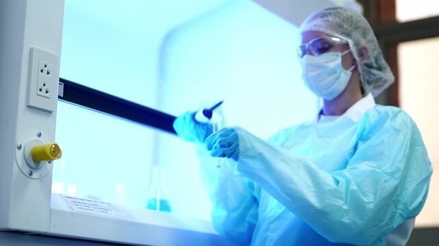 Scientist in protective gear performing precise chemical analysis inside a sterile laboratory