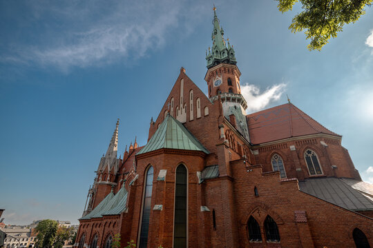 Krakow, Poland - July 18, 2026: Low-angle side view of the red-brick Neo-Gothic St. Joseph&rsquo;s Church in Podgorze.