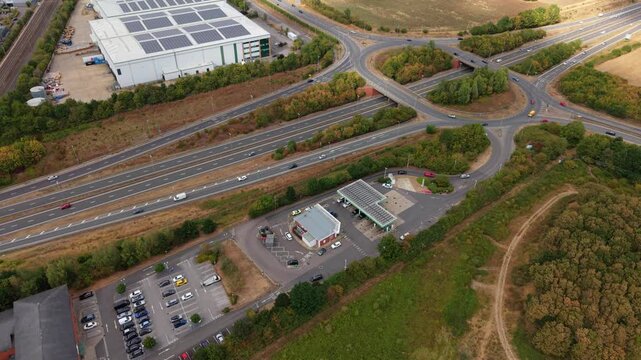Aerial view of busy petrol station forecourt with queuing traffic waiting for fuel in Bedford, UK