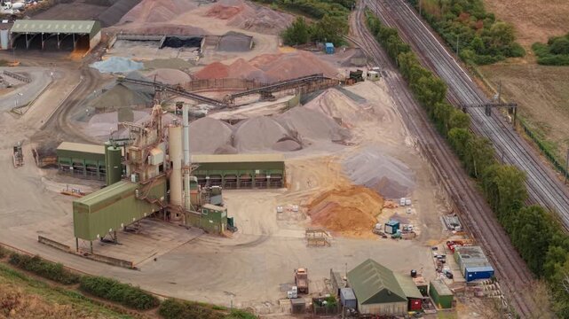 Aerial view of an asphalt manufacturing plant and aggregate processing facility with heavy machinery in Bedford, UK