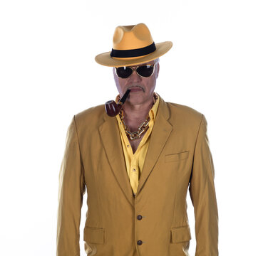Portrait of a cheerful old man in yellow clothing and a yellow hat, isolated on a white studio background.