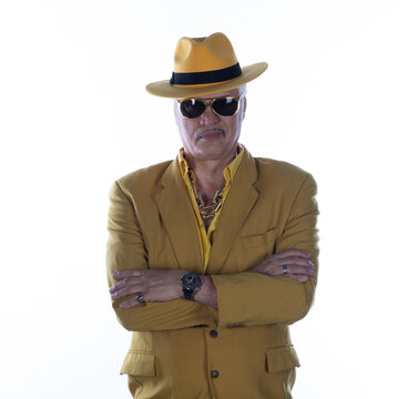 Portrait of a cheerful old man in yellow clothing and a yellow hat, isolated on a white studio background.