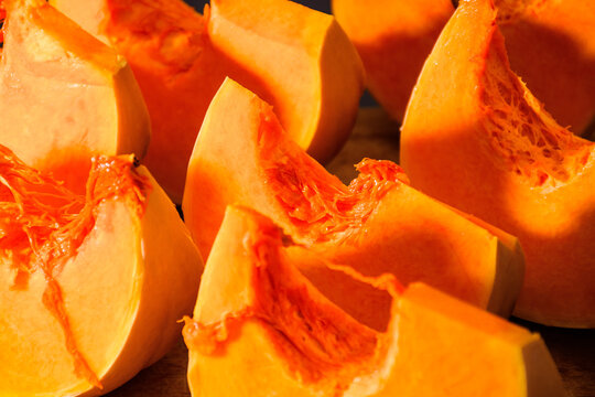 pumpkin slice on wooden board. orange autumn vegetable. thanksgiving food ingredient. cut in to pieces