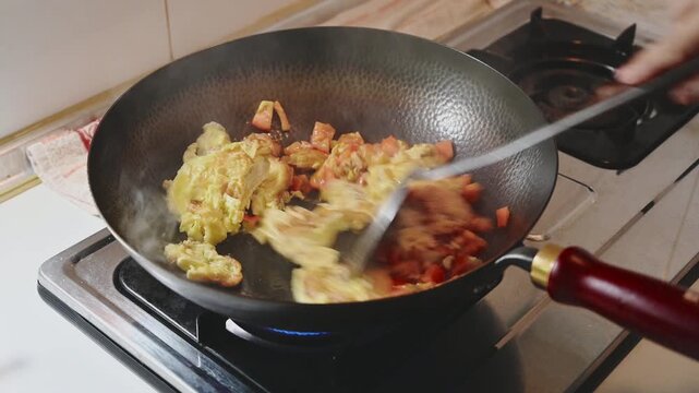 Stir Frying Tomatoes with Scrambled Eggs in an Iron Wok