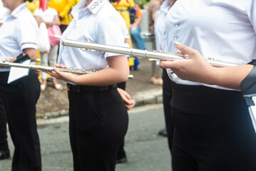 Students holding flutes participating in a marching band parade © Kenneth Arrieta 