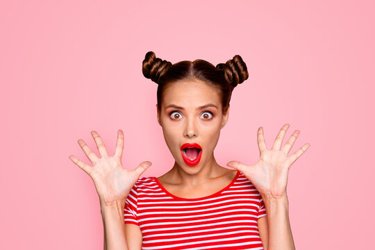 Closeup portrait of shocked girl with brown eyes and red lipstick on the mouse look at the camera with his fingers spread wide. Concept of advertising isolated on red background