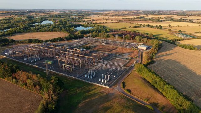 Aerial view of massive 400kV electrical substation with busbars, transformers, and transmission switchgear in Grendon, UK