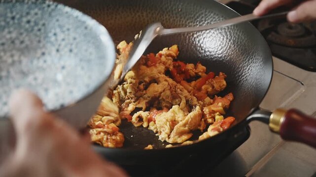 Stir Frying Tomatoes with Scrambled Eggs in an Iron Wok