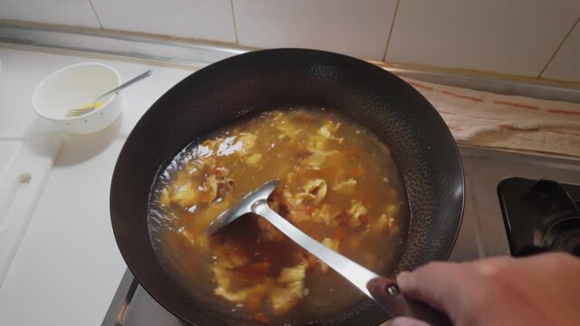 Boiling Tomato and Egg Soup in a Traditional Iron Wok