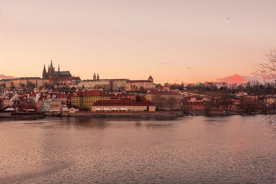 Panoramic view of Prague Castle and Saint Vitus Cathedral across the Vltava River at sunset in Prague, Czech Republic.