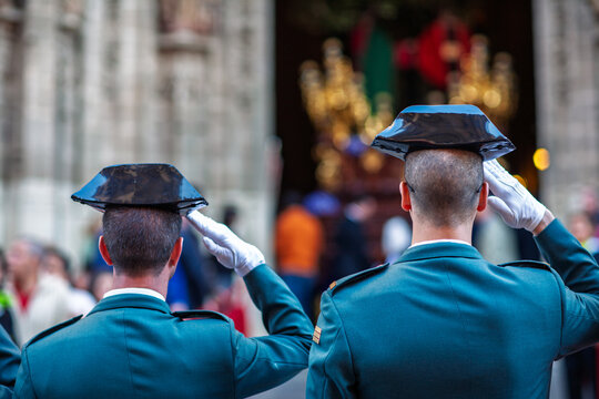Members of the Guardia Civil, wearing traditional tricornio hats, salute a Holy Week procession float