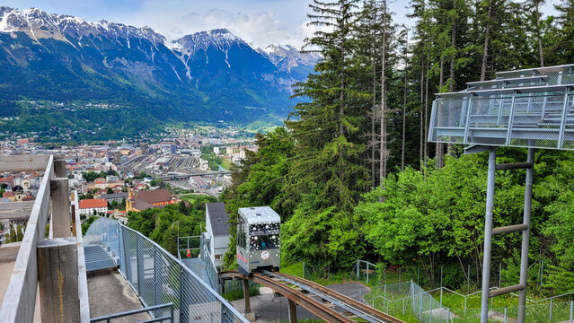 INNSBRUCK, AUSTRIA - May 19, 2023. The Leitner inclined elevator at the Bergisel ski jump complex with Innsbruck and the Nordkette Alpine mountain range in the background.